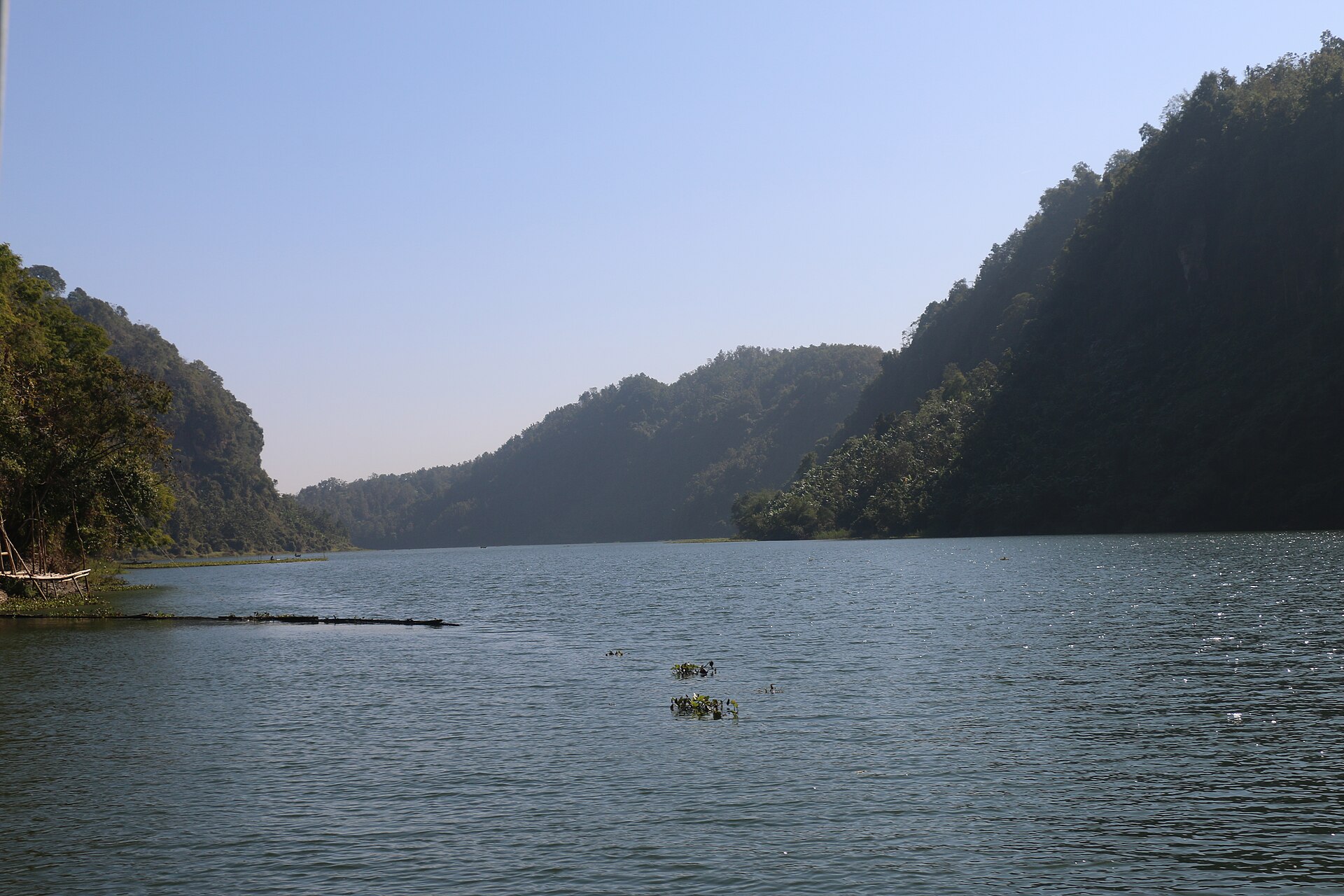 Still water of Kaptai Lake between forested hills