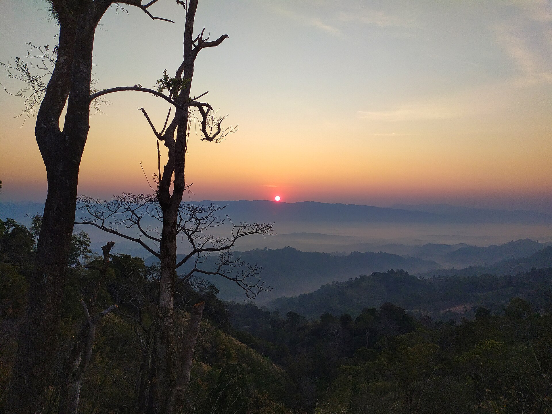 Sun rising over layered ridges and mist at Sajek Valley